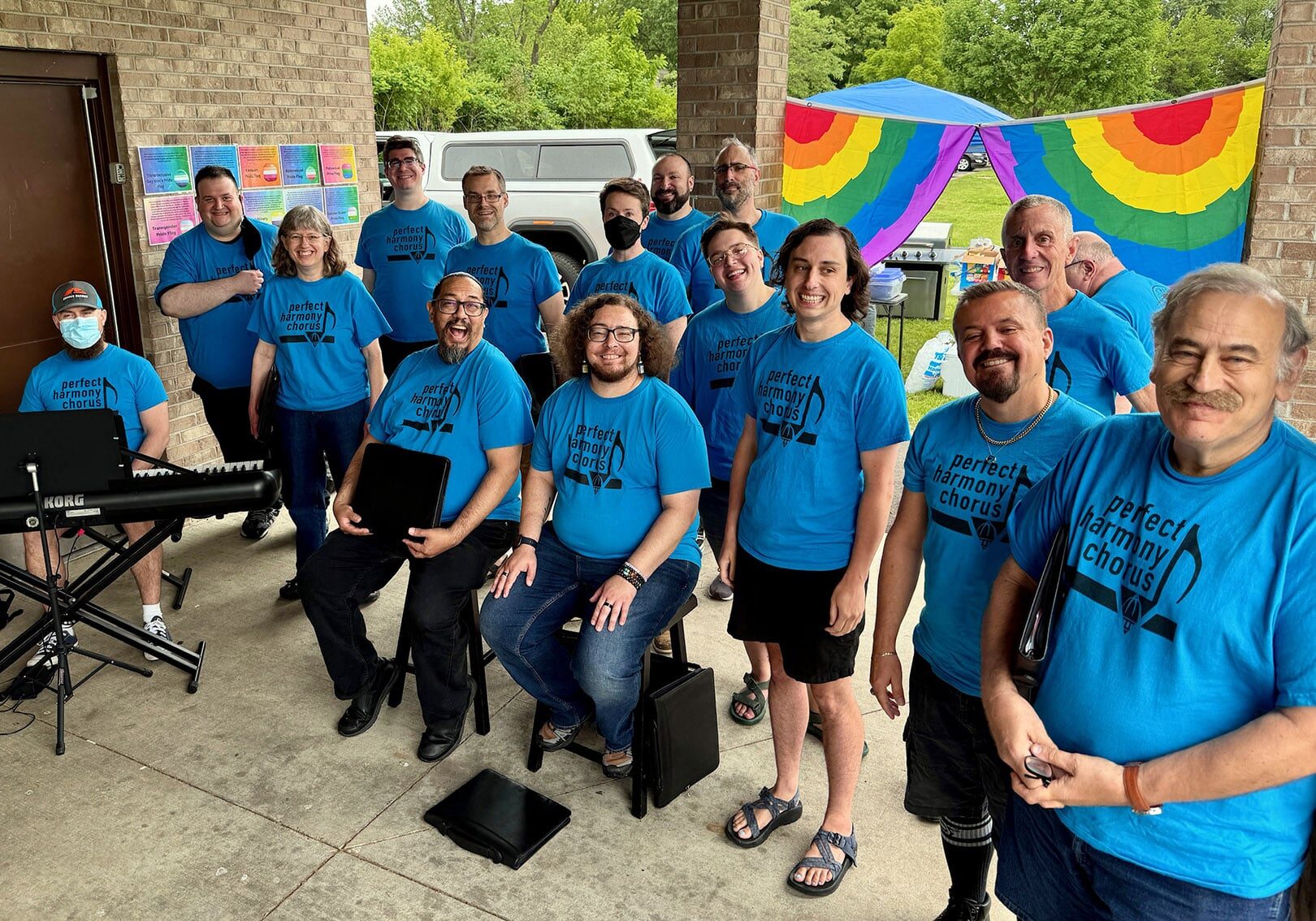 PHC members clad in blue t-shirts pose for a photo before a community performance